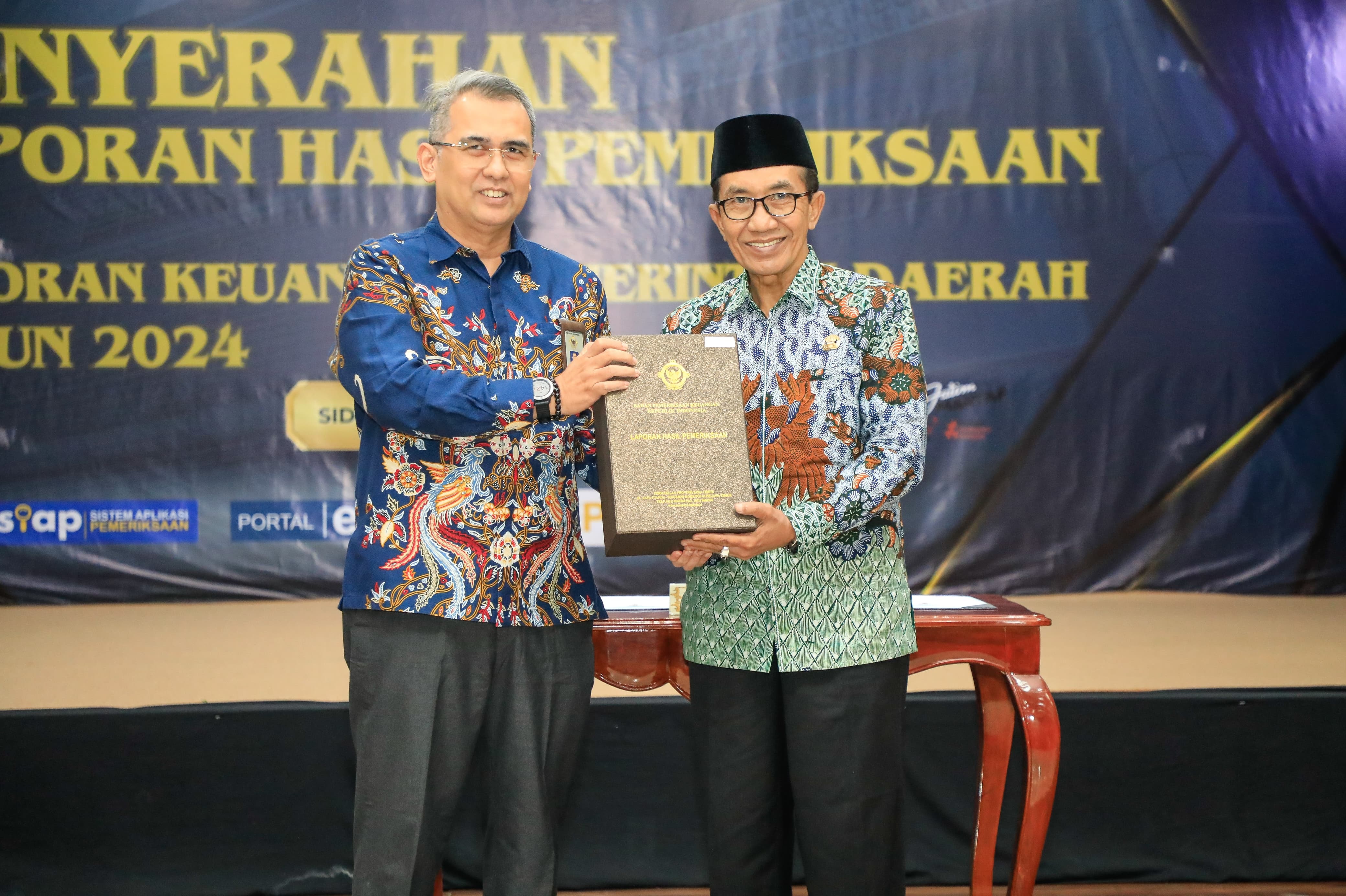 BERSINERGI: Bupati Pamekasan KH Kholilurrahman (kanan) menerima LHP dari Kepala BPK Perwakilan Jawa Timur Yuan Candra Djaisin, Senin (21/4). (PROKOPIM PAMEKASAN&nbsp;UNTUK JPRM)