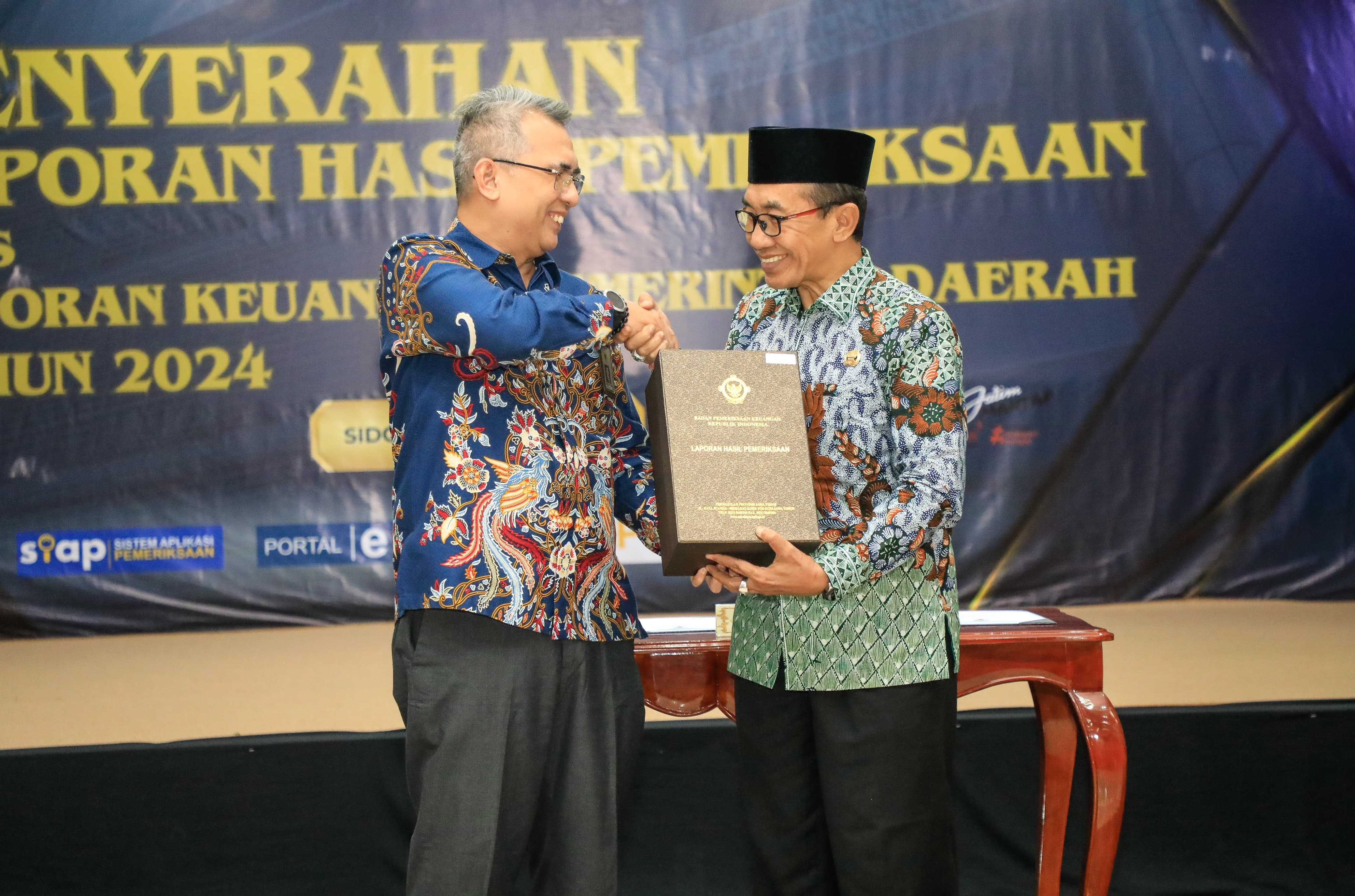 BERSINERGI: KH Kholilurrahman (kanan) menerima LHP dari Kepala BPK Perwakilan Jawa Timur Yuan Candra Djaisin. (PROKOPIM PAMEKASAN UNTUK JPRM)