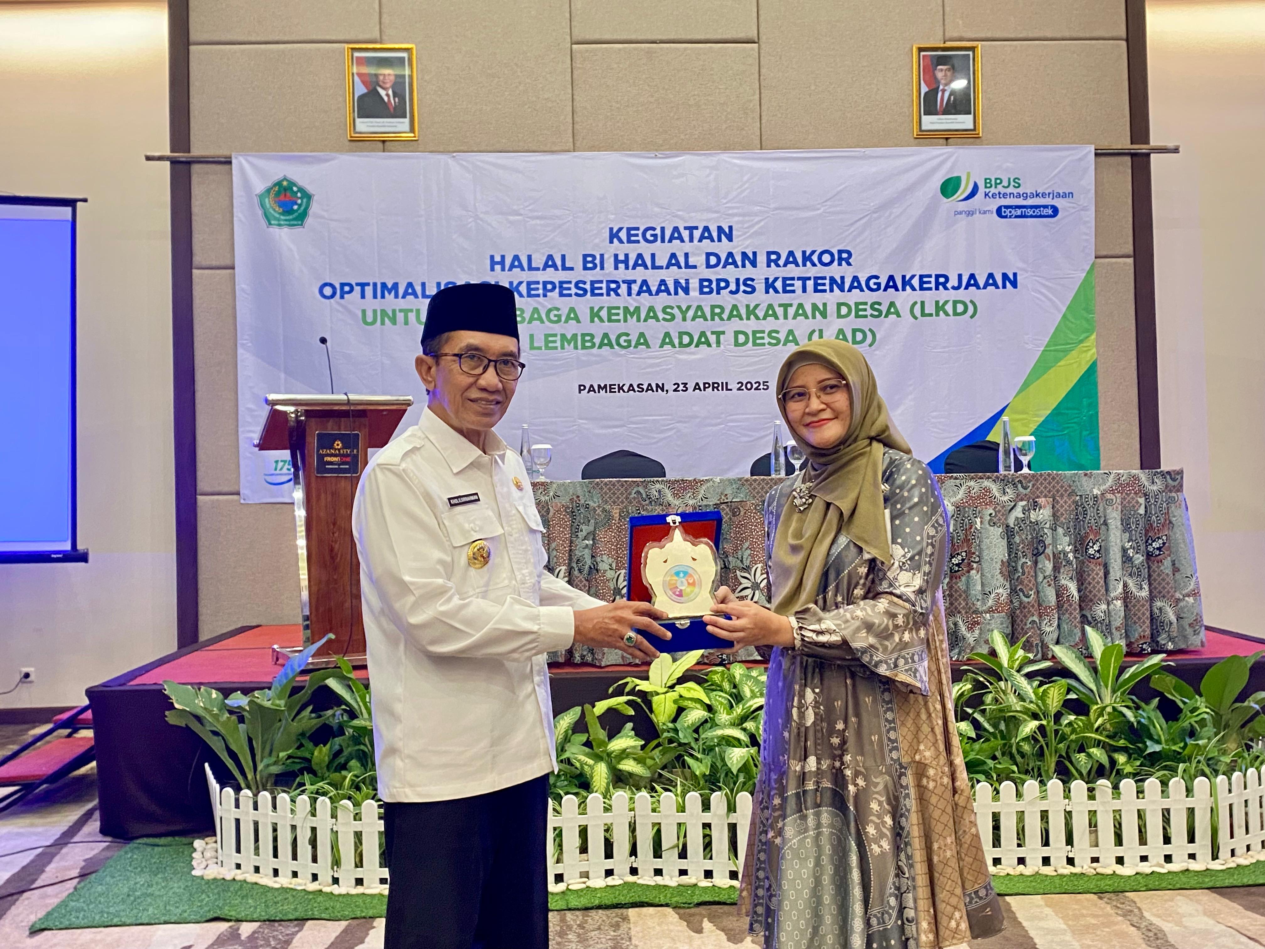 BERSINERGI: Kepala BPJamsostek Pamekasan Anita Ardhiana menyerahkan cindera mata kepada Bupati Pamekasan KH. Kholilurrahman di Front One Hotel Pamekasan, Rabu (23/4).