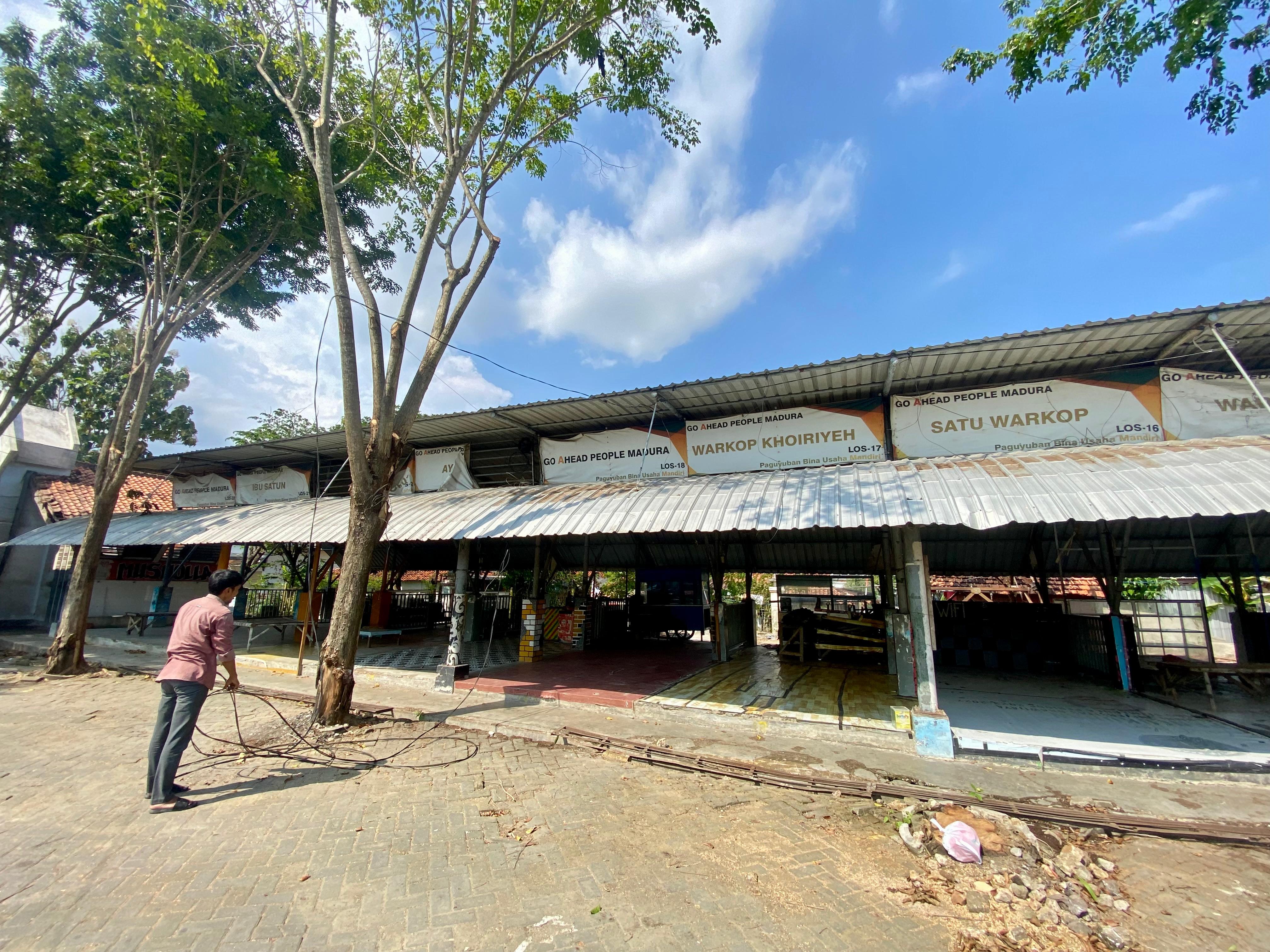 MASIH SEPI: Warga membereskan sisa-sisa barang yang berserakan di kios eks Stasiun PJKA Pamekasan, Kamis (24/4). (MOH. IQBAL AFGANI/JPRM)