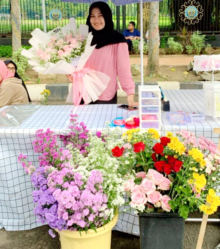 POTENSIAL: Siti Maryam buka stan penjualan bunga di Alun-Alun Bangkalan, Minggu (13/4). (SITI MARYAM UNTUK JPRM)