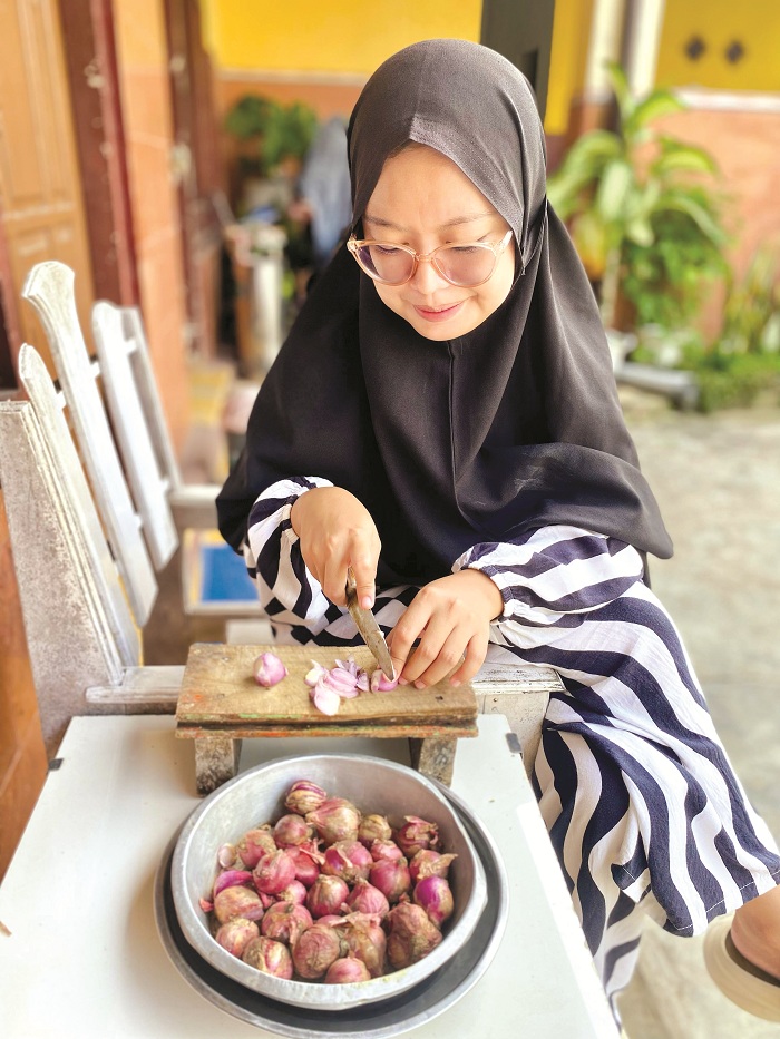 PELENGKAP BUMBU: Iffah Al-Abadiyah mengiris bawang merah di rumahnya di Desa Waru Barat, Kecamatan Waru, Pamekasan, Jumat (25/4). (MOH. IQBAL AFGANI/JPRM)