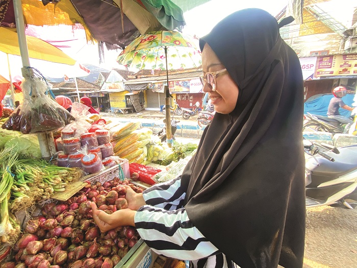 BERSAING: Iffah Al-Abadiyah membeli bawang merah di Pasar Waru, Pamekasan, Jumat (25/4). (MOH. IQBAL AFGANI/JPRM)