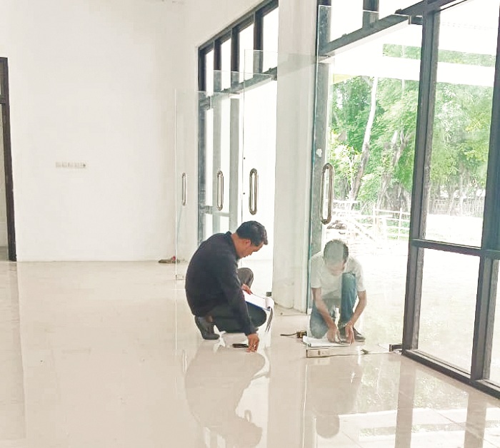 JADI CATATAN: Auditor BPK mengukur pintu Puskesmas Mandangin, Sampang, Senin (10/2). (PUSKESMAS MANDANGIN UNTUK JPRM)