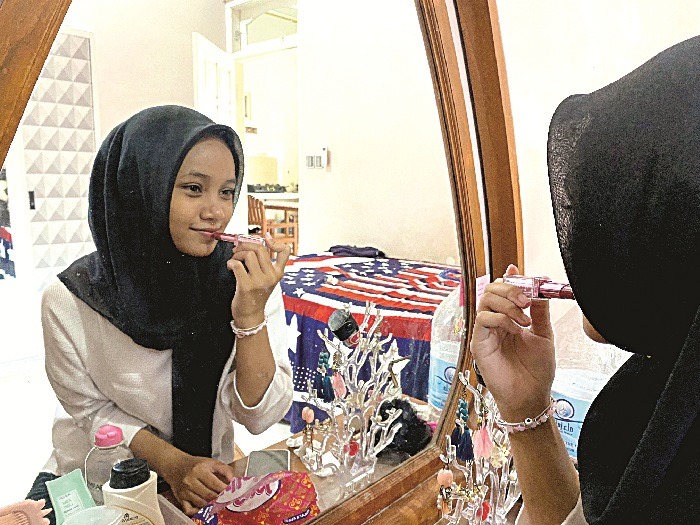 PELEMBAP: Khairina Balqis Batrisya mengaplikasikan lip butter ke bibirnya Sabtu (19/4). (AYU LATIFAH/JPRM)