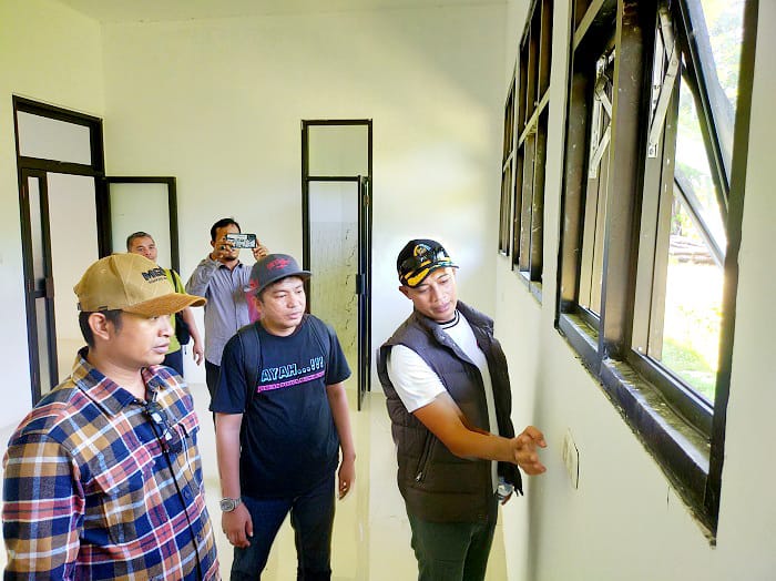 SIDAK: Ketua Pansus LKPj Bupati Sampang 2024 Alan Kaisan dan anggota Mohammad Salim mengecek dinding Puskesmas Mandangin , Sabtu (26/4). (ANIS BILLAH/JPRM)
