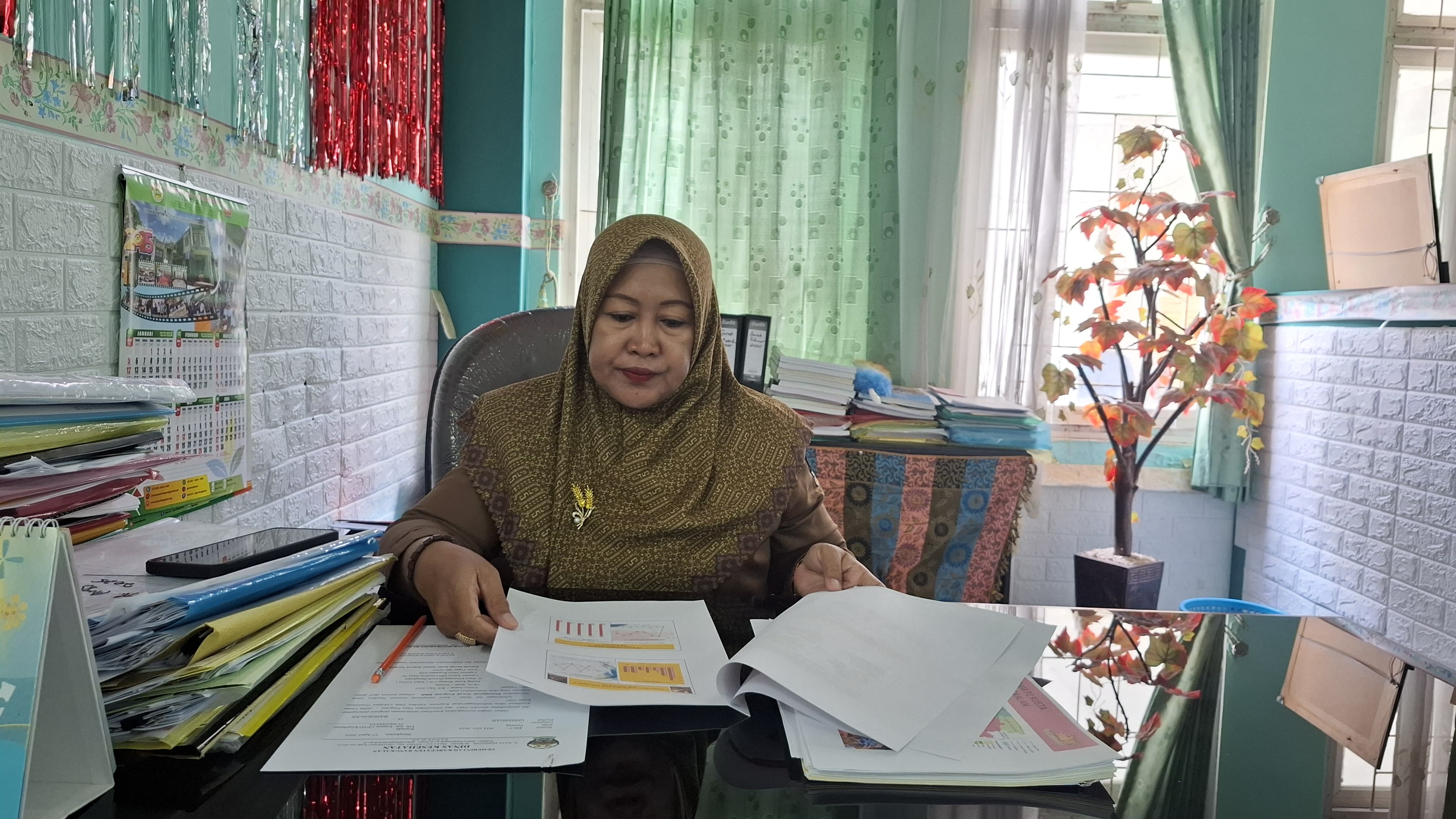 MEMBERIKAN KETERANGAN: Kasi P2PM Dinkes Bangkalan Mariamah mengecek data penderita kusta di meja kerjanya, Senin (28/4). (IMAMUDIN/JPRM)