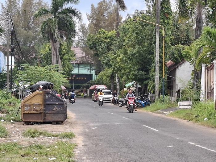 BUTUH PENANGANAN: Warga melintas di depan kontainer sampah yang ada di area GOR A. Yani Sumenep. (MOH. LATIF/JPRM)