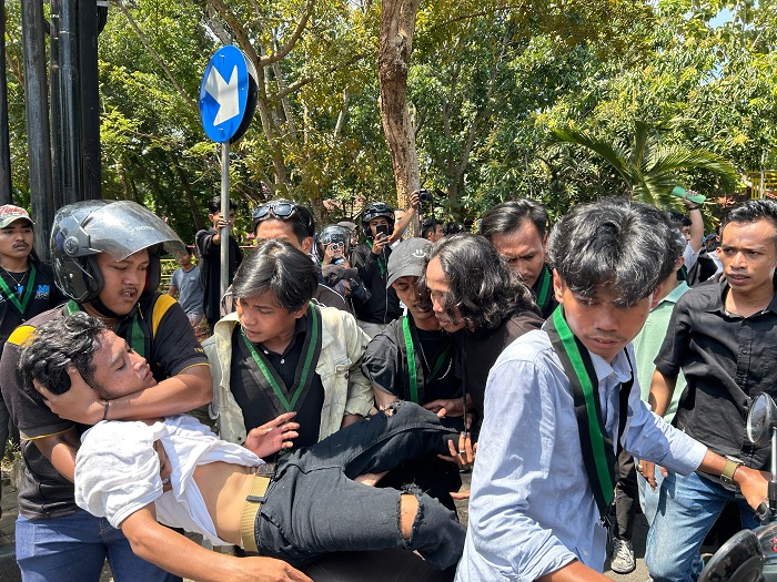 RICUH: Massa aksi dibopong rekannya setelah mendapat tindakan represi dari petugas keamanan di depan Mapolres Bangkalan, Rabu (30/4). (VIVIN AGUSTIN HARTONO/JPRM)