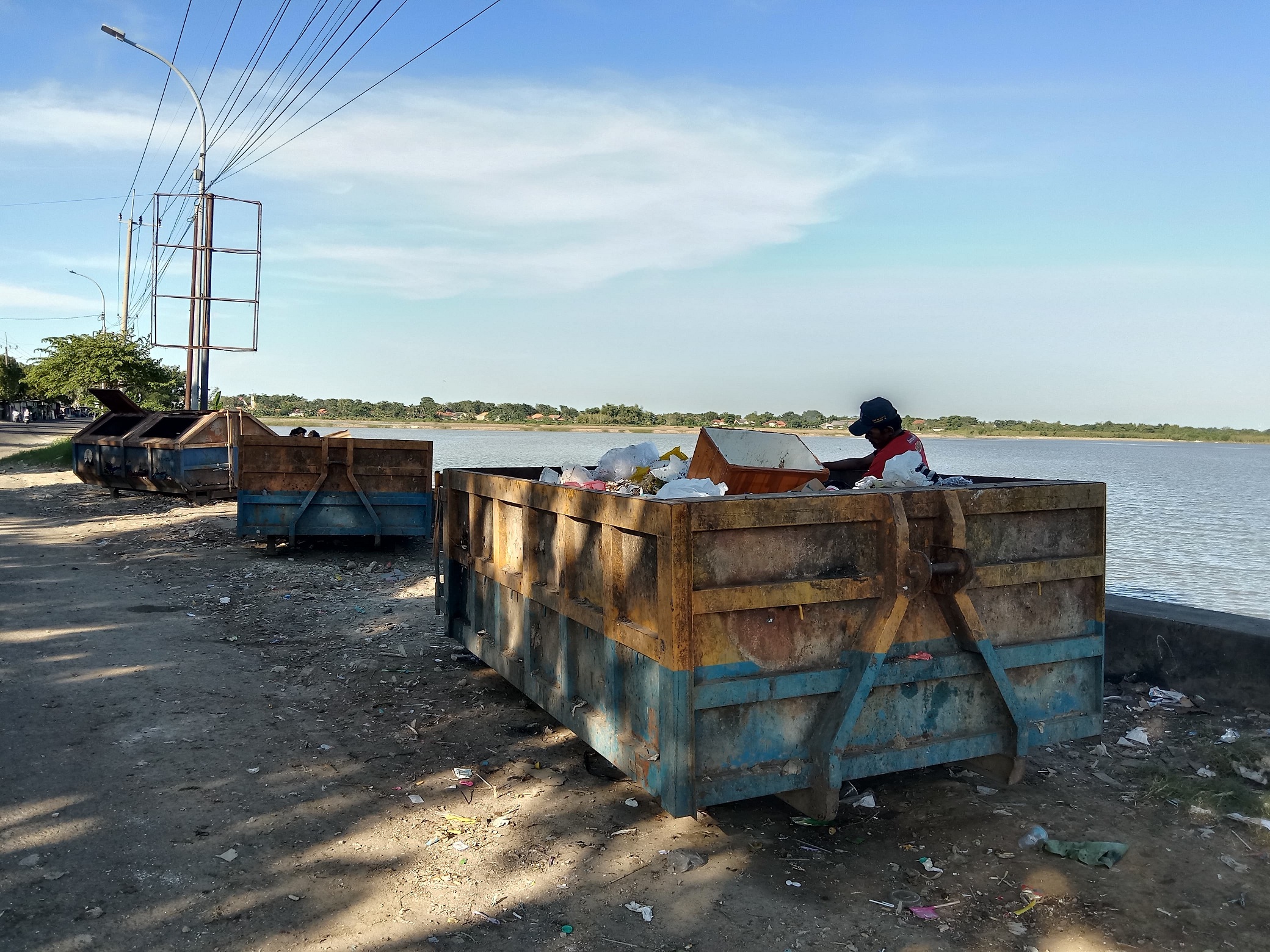 BERSIH: Petugas membuang sampah ke kontainer di Jalan Raya Lenteng&ndash;Batuan Sumenep, Desa Pabian, Kecamatan Kota Sumenep, kemarin. (ERWIN MAULIDIN MM/JPRM)