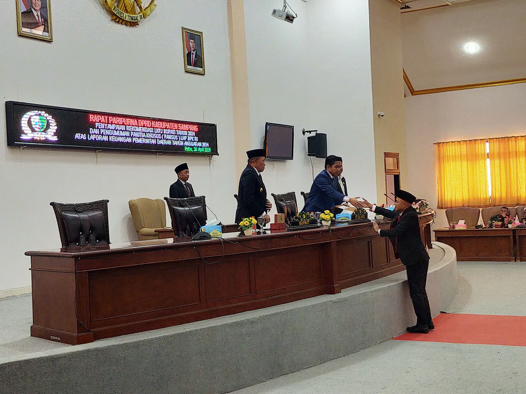 HARUS DITINDAKLANJUTI: Ketua Pansus LKPj Bupati Sampang 2024 Alan Kaisan menyerahkan rekomendasi kepada Ketua DPRD Sampang Rudi Kurniawan saat rapat paripurna Rabu (30/4). (ANIS BILLAH/JPRM)