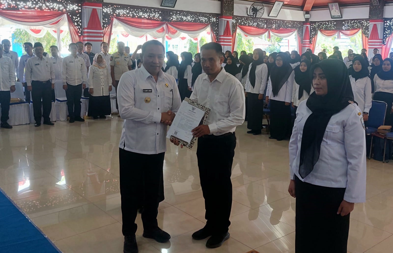 SIMBOLIS: Bupati Slamet Junaidi (kiri depan) menyerahkan petikan SK kepada ASN di Pendopo Trunojoyo, Sampang, Rabu (30/4). (JUNAIDI PONDIYANTO/JPRM)