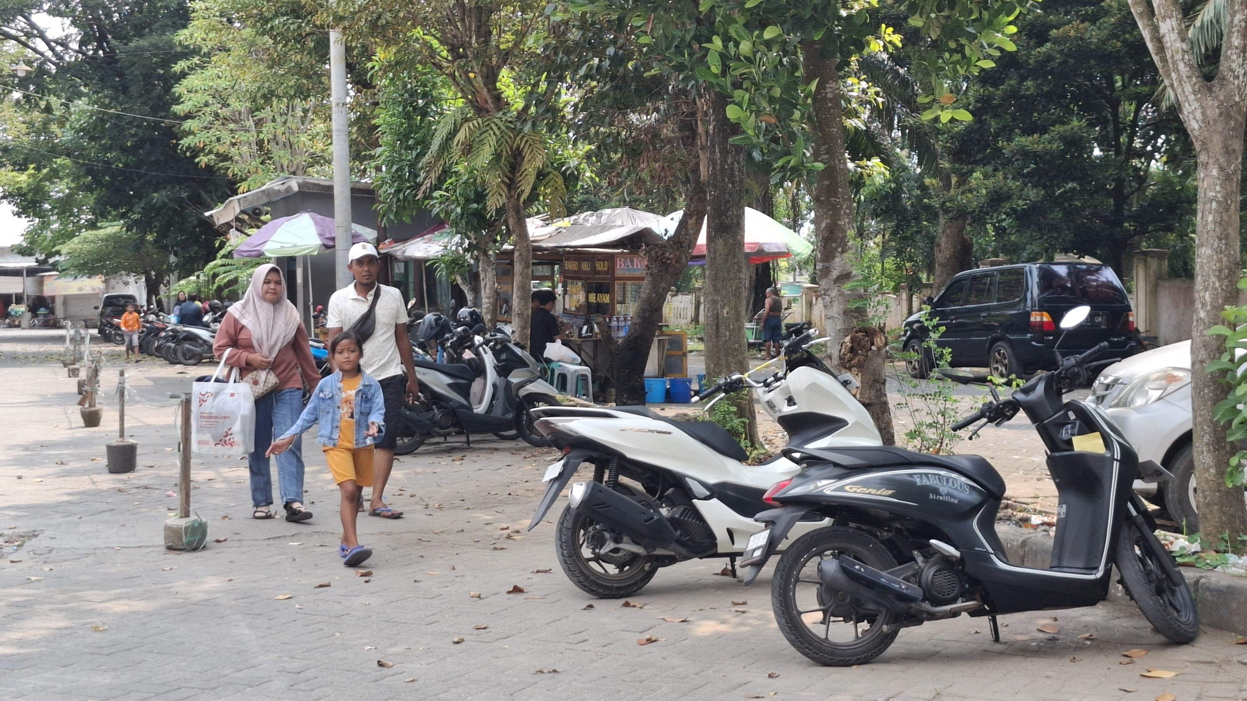 PUSAT EKONOMI: Pengunjung berada di area parkir kendaraan di Pasar KLD Bangkalan, Kamis (1/5). (IMAMUDIN/JPRM)