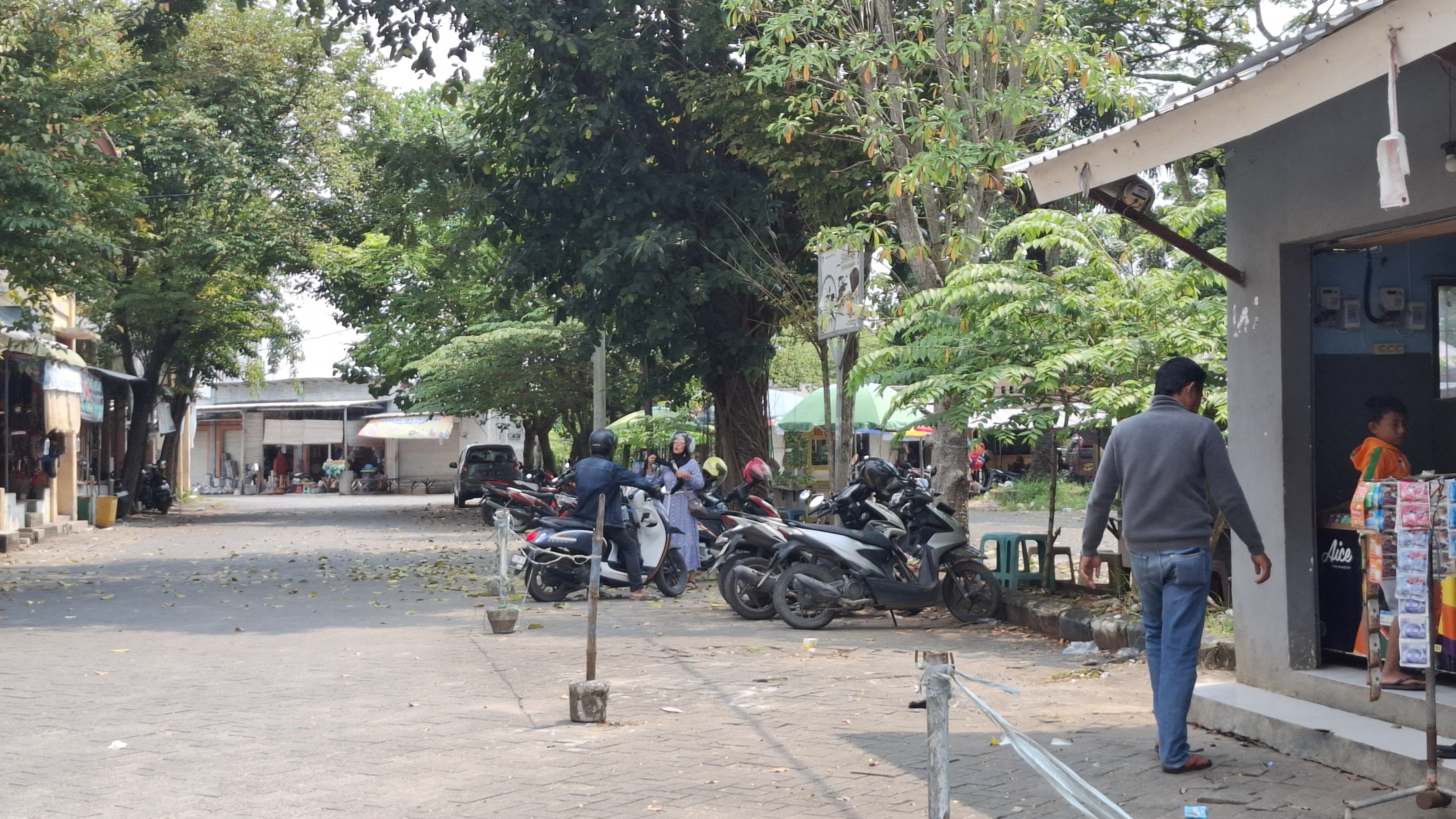 SUMBER PAD: Warga sedang berjalan di area parkir sepeda motor di Pasar KLD Bangkalan kemarin. (IMAMUDIN/JPRM)