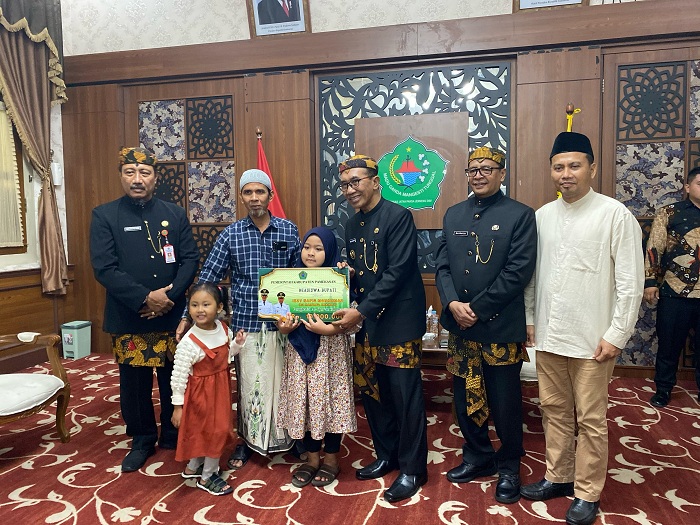 PEDULI: Bupati Kholilurrahman menyerahkah beasiswa kepada Izzi Nafis Mohammad di Peringgitan Dalam Mandhapa Ronggosukowati, Jumat (2/5). (AYU LATIFAH/JPRM)