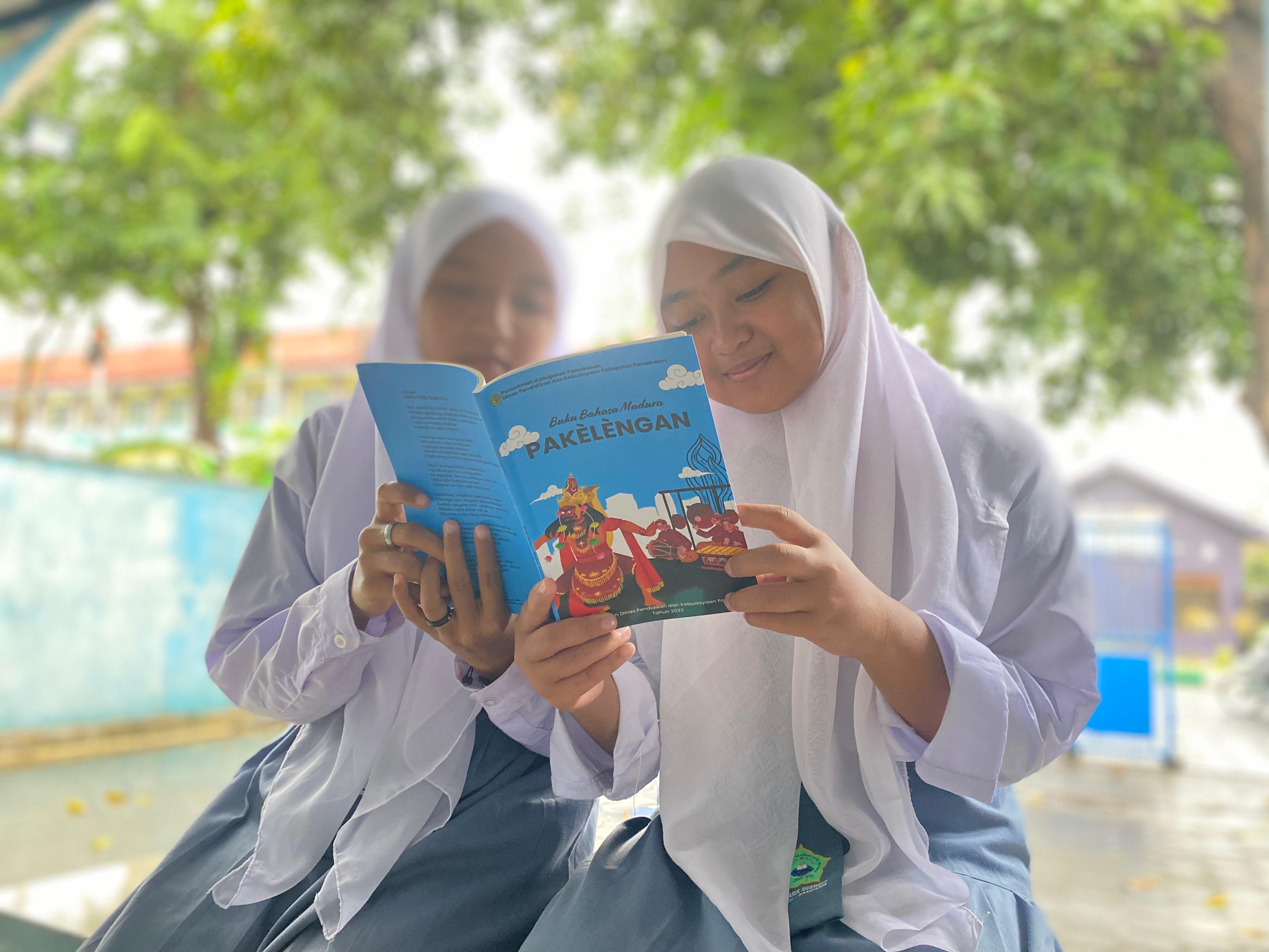 PENDIDIKAN: Siswa sedang membaca buku di Jalan Kabupaten, Pamekasan. (AYU LATIFAH/JPRM)