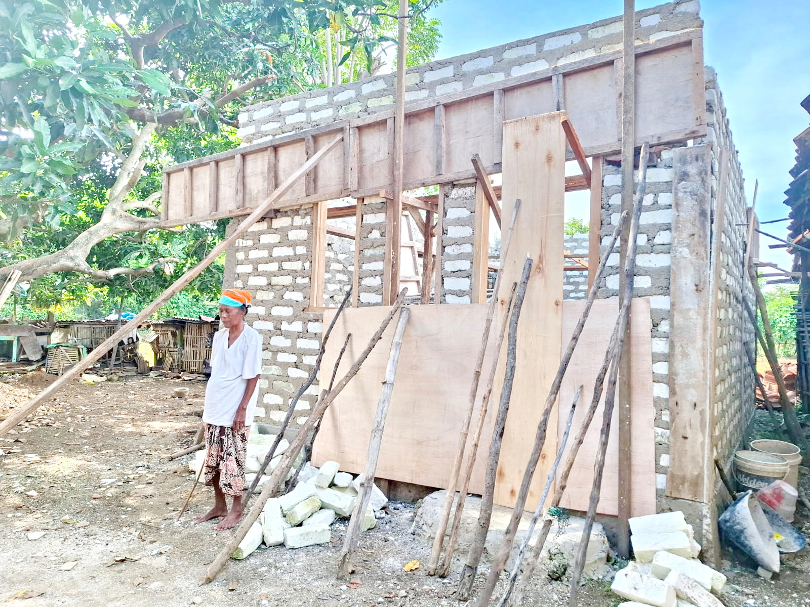 TERBENGKALAI: Mu&rsquo;ade berada di depan rumah bantuan program BSPS di RT 1, RW 3, Dusun Darpa, Desa Karang Nangka, Kecamatan Raas, Sumenep, Senin (21/4). (MOH. IQBAL/JPRM)