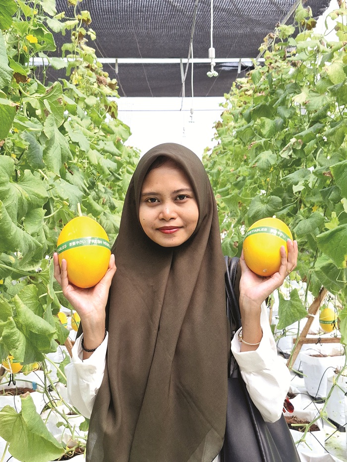 MANIS: Pengunjung berpose dengan melon yang dibeli di Agrowisata Green Aries di Desa Karangbudi, Kecamatan Gapura, Sumenep, Sabtu (26/4). (MOH. LATIF/JPRM)