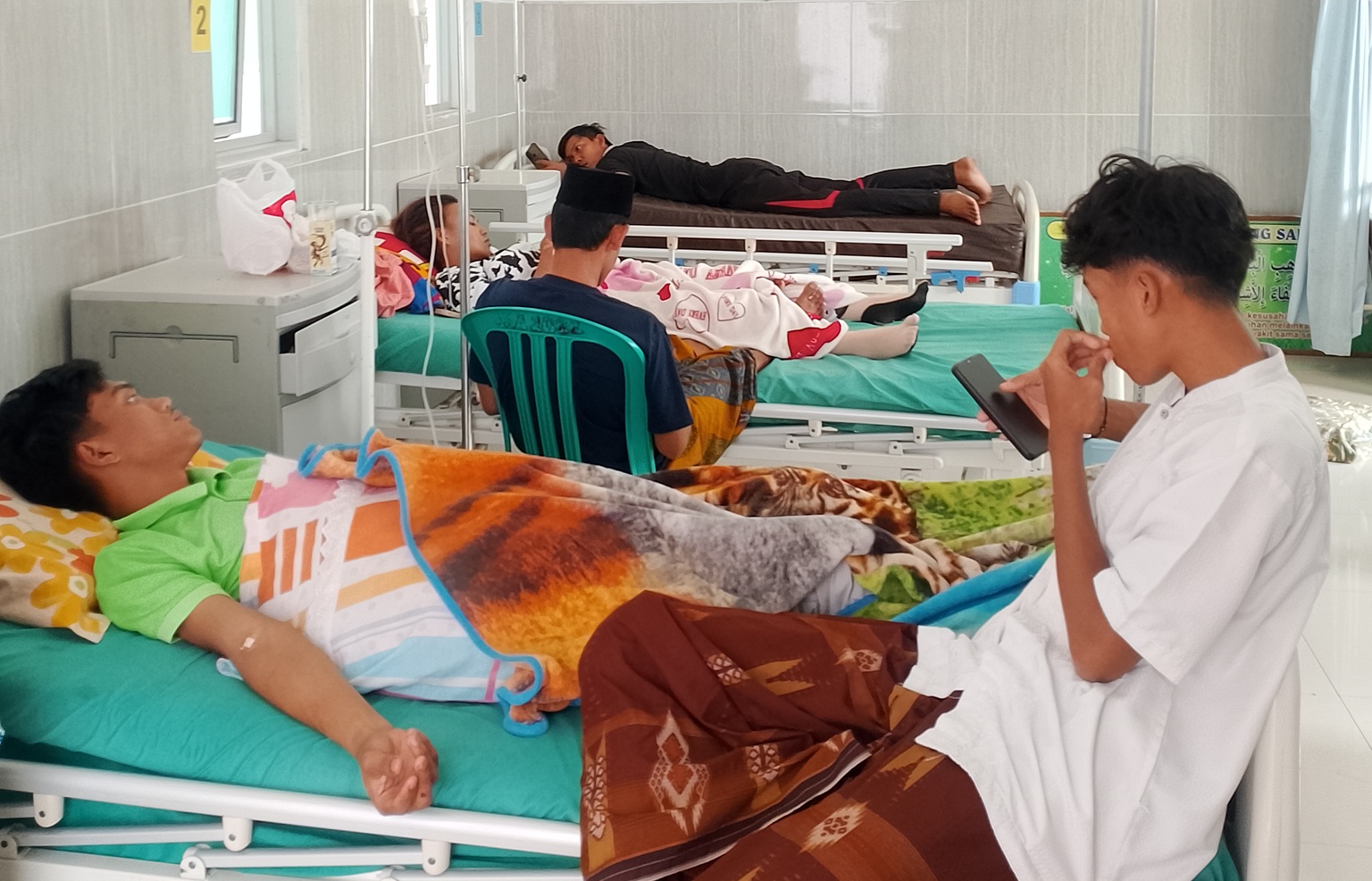 DIOBATI: Pasien tengah menjalani perawatan di Puskesmas Banyuanyar, Sampang, kemarin. (UBAIDILLAHIR RA&rsquo;IE/JPRM)