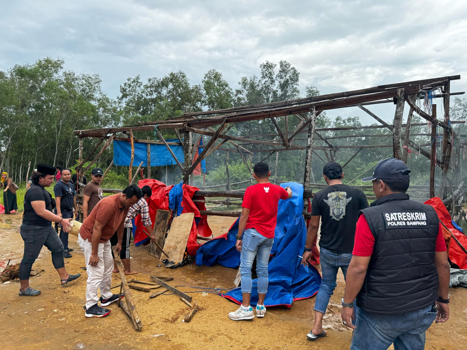 DIBONGKAR: Anggota Polres Sampang melakukan penggerebekan arena judi sabung ayam di Desa Batuporo Barat, Kecamatan Kedungdung, Sabtu (3/5). (HUMAS POLRES UNTUK JPRM )