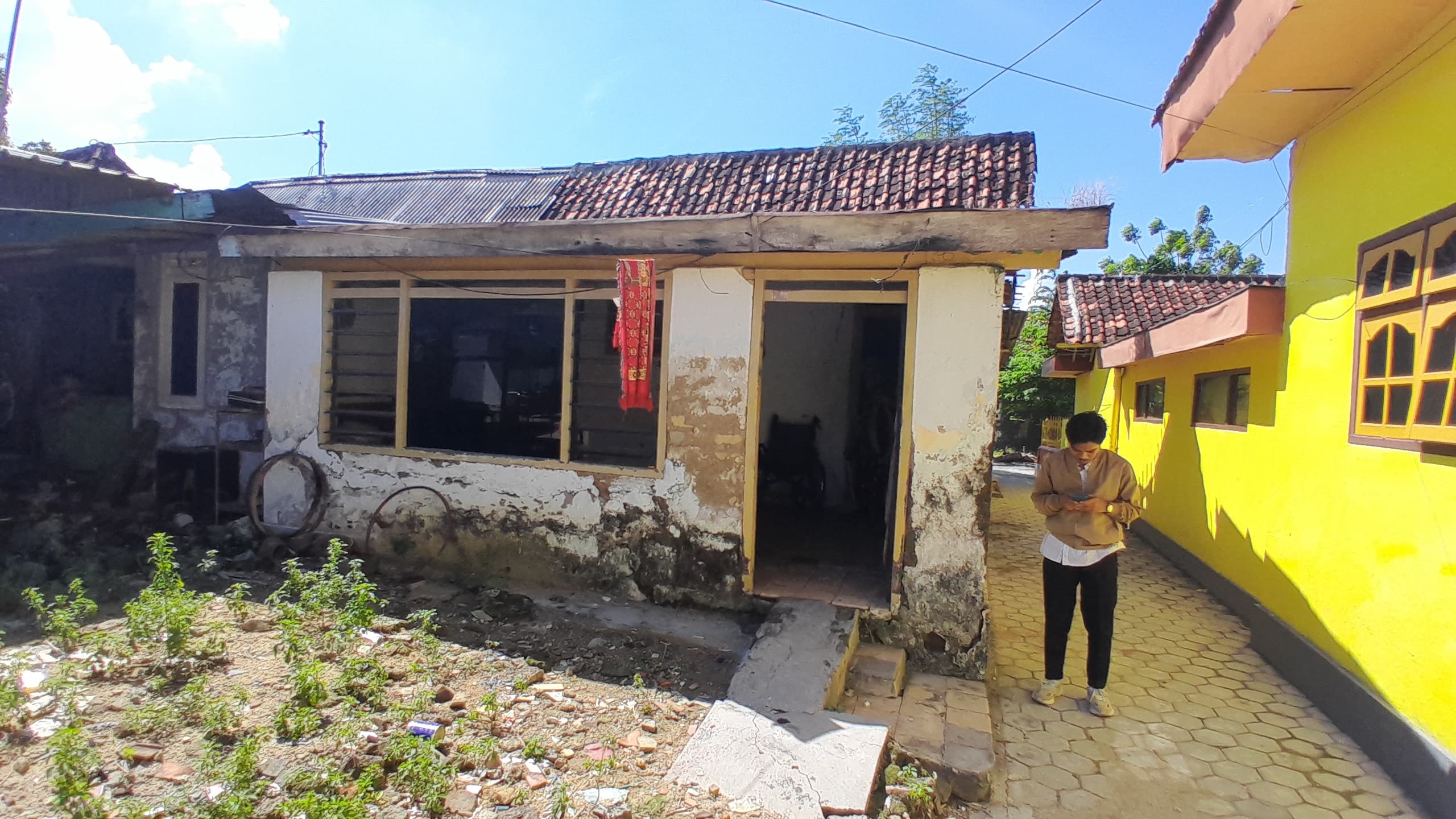 TIDAK LAYAK HUNI: Seorang warga berada di samping rumah Slamet di Kelurahan Jugcangcang, Pamekasan, Senin (5/5). (KHOLIL RAMLI/JPRM)