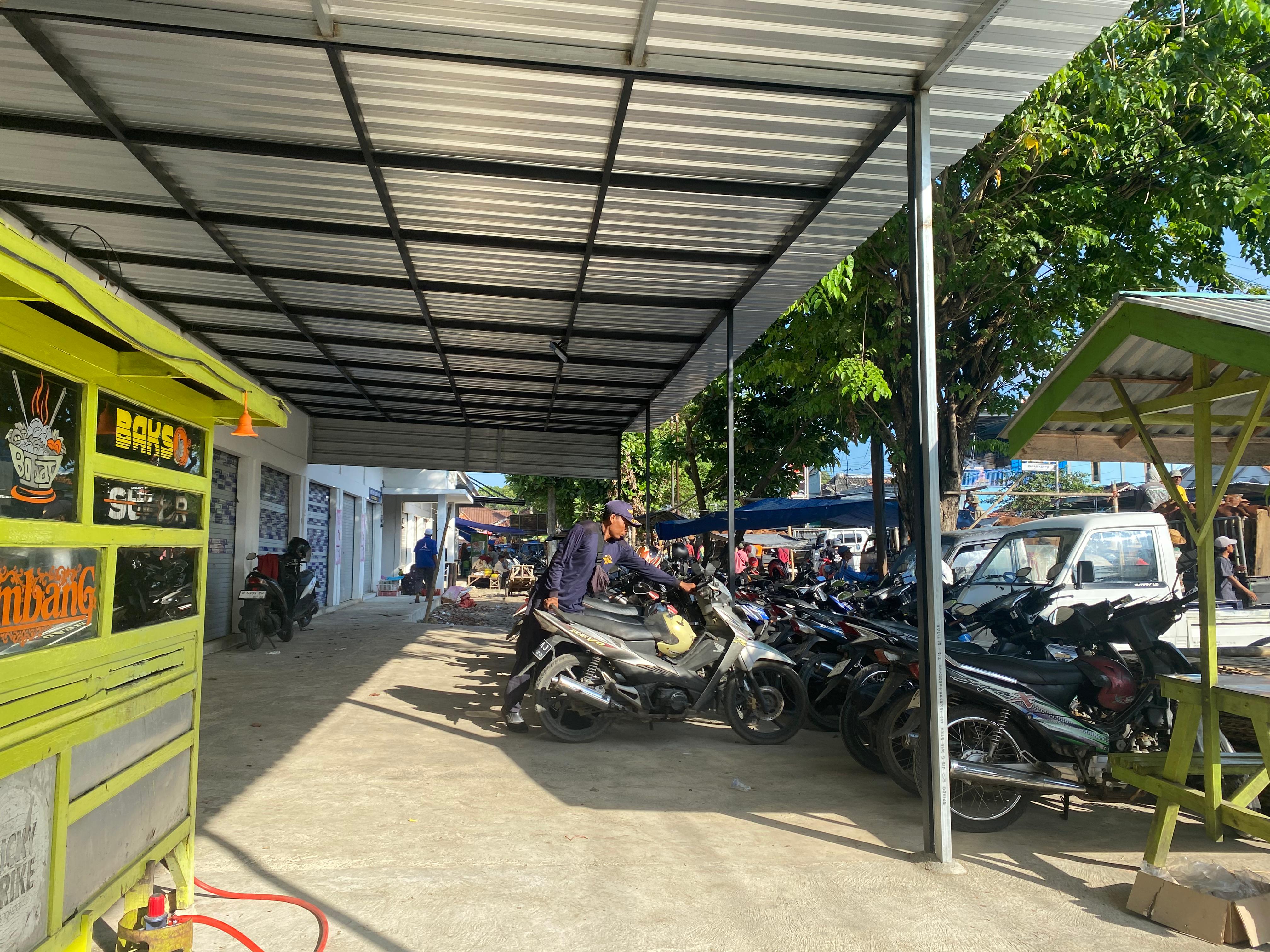 RINDANG: Petugas memarkirkan motor di Pasar Keppo, Selasa (6/5). (MOH. IQBAL AFGANI/JPRM)