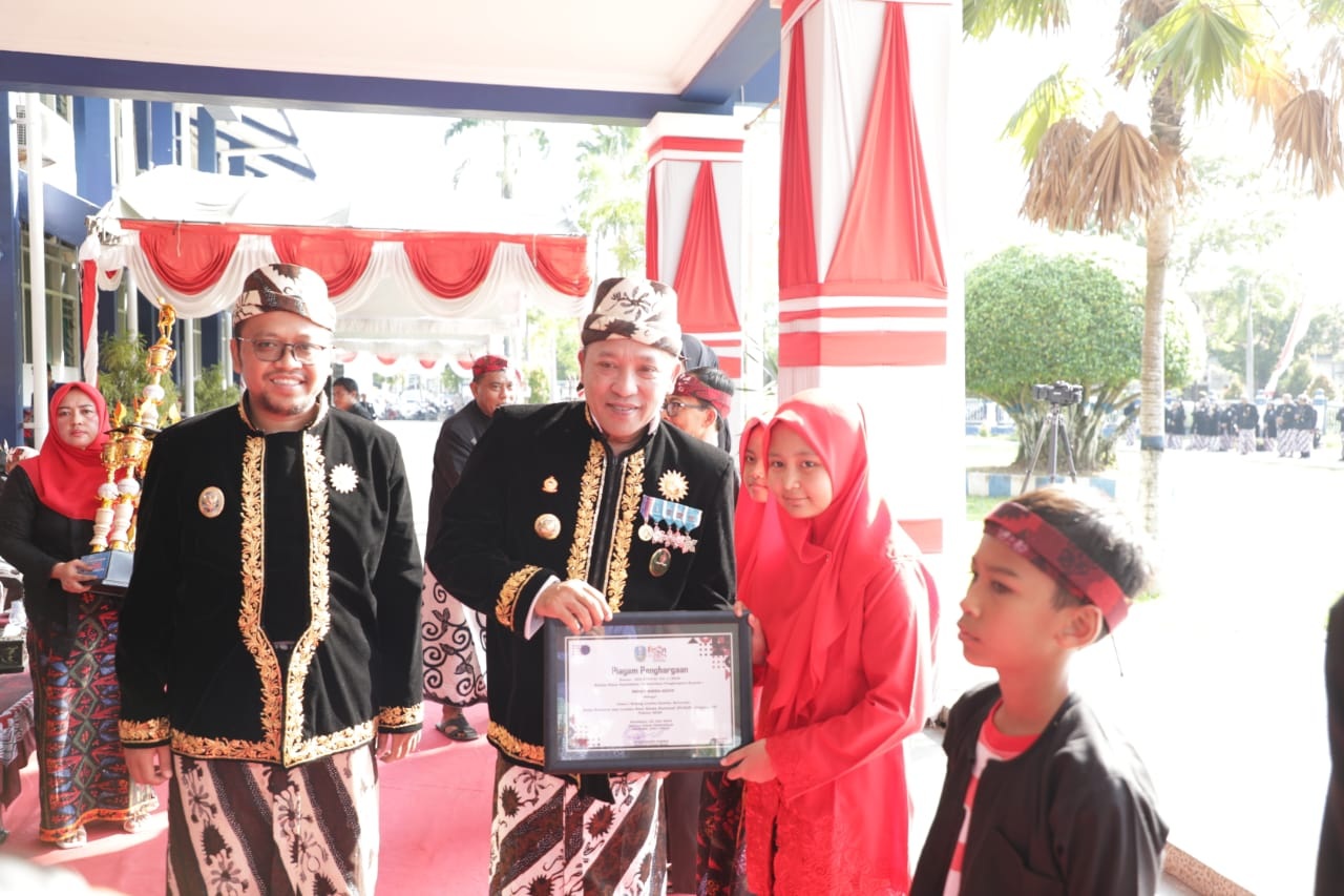 APRESIASI: Bupati Sampang Slamet Junaidi didampingi Wabup Ahmad Mahfudz memberikan penghargaan kepada siswa berprestasi dalam rangka Hardiknas, Jumat (2/5).