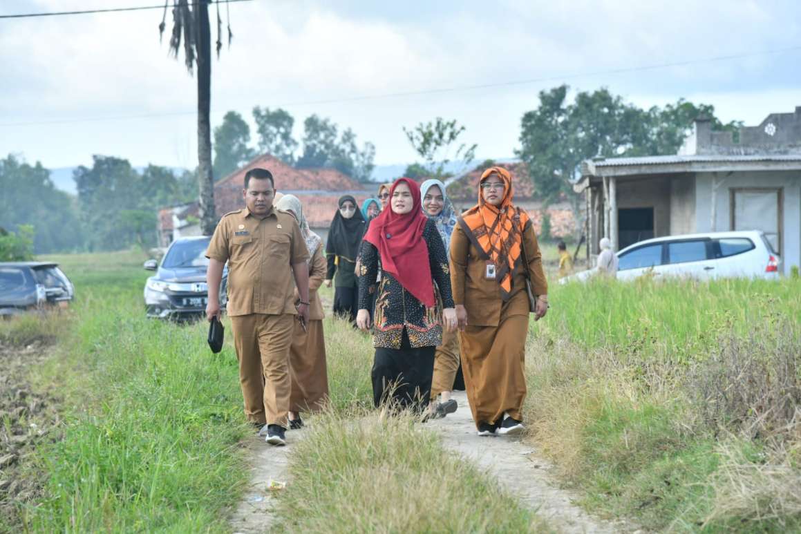 TANPA LELAH: Ketua TP PKK Sumenep Nia Kurnia Fauzi (tengah) menuju rumah anak terkena tengkes di Desa Prancak, Kecamatan Pasongsongan, Selasa (6/5). (PROKOPIM SUMENEP UNTUK JPRM)