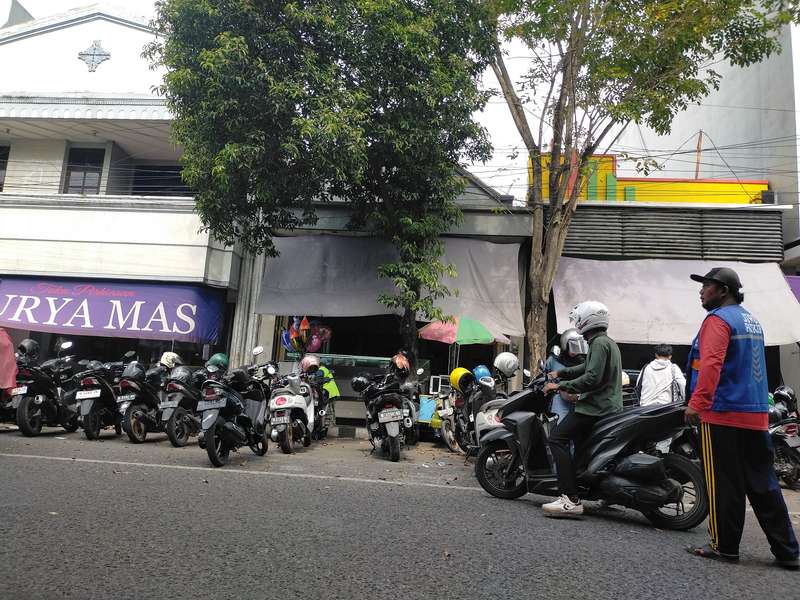 PROGRAM PARKIR BERLANGGANAN: Jukir di ruas Jalan Panglima Sudirman, Bangkalan, mengawal pengendara sepeda motor Kamis (7/5). (VIVIN AGUSTIN HARTONO/JPRM)