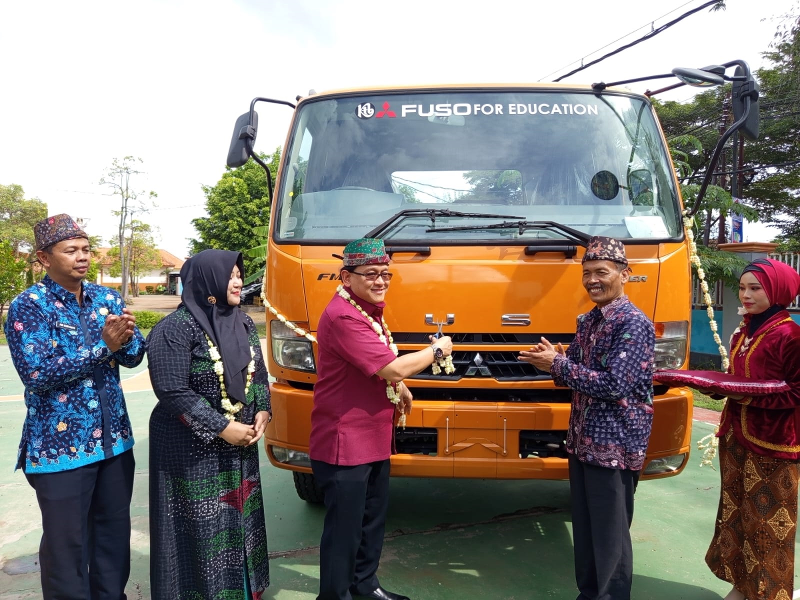 SERAH TERIMA: Administration dan HR Deractur PT KTB Prasetio Hartono (baju marun) menyerahkan hibah unit Mitsubishi Fuso Fighter ke SMK Negeri 1 Kamal kemarin.  (IMAMUIDN/JPRM)