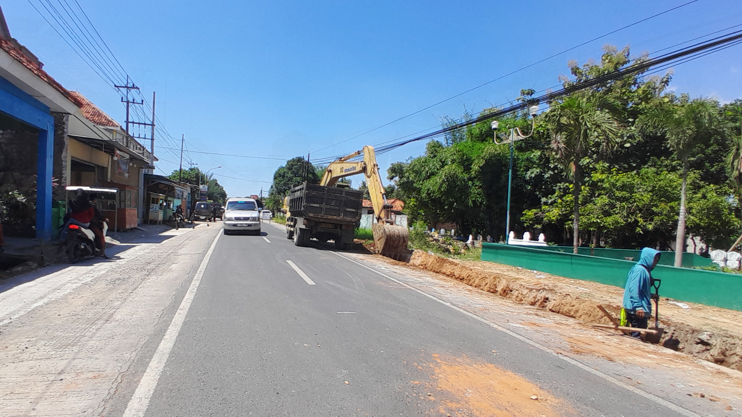 PELEBARAN JALAN: Pekerja melakukan pengerukan median jalan lintas kabupaten di depan Kantor Urusan Agama (KUA) Kecamatan Proppo, Minggu (11/5). (M. KHOLIL RAMLI/JPRM)