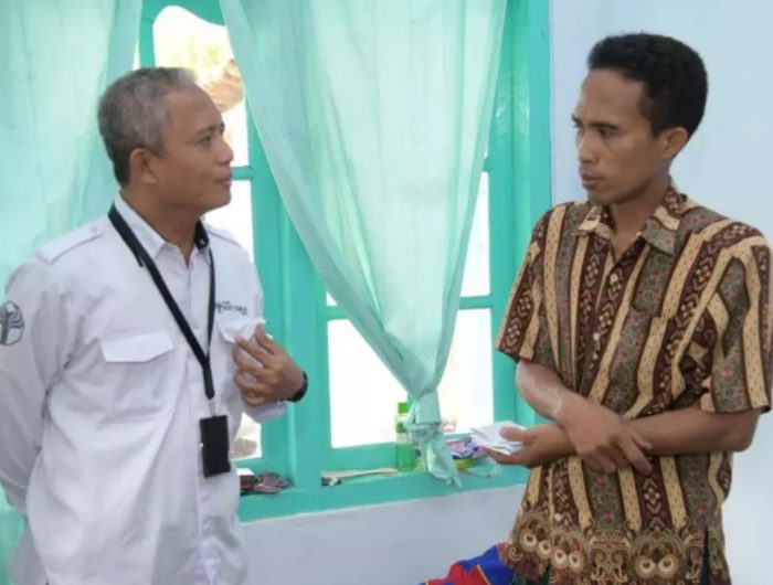 PEDULI:Direktur Utama BPRS Bhakti Sumekar Hairil Fajar berbincang dengan korban Slamet Riyadi di Desa Kalianget Barat, Kecamatan Kalianget. (BPRS UNTUK JPRM)