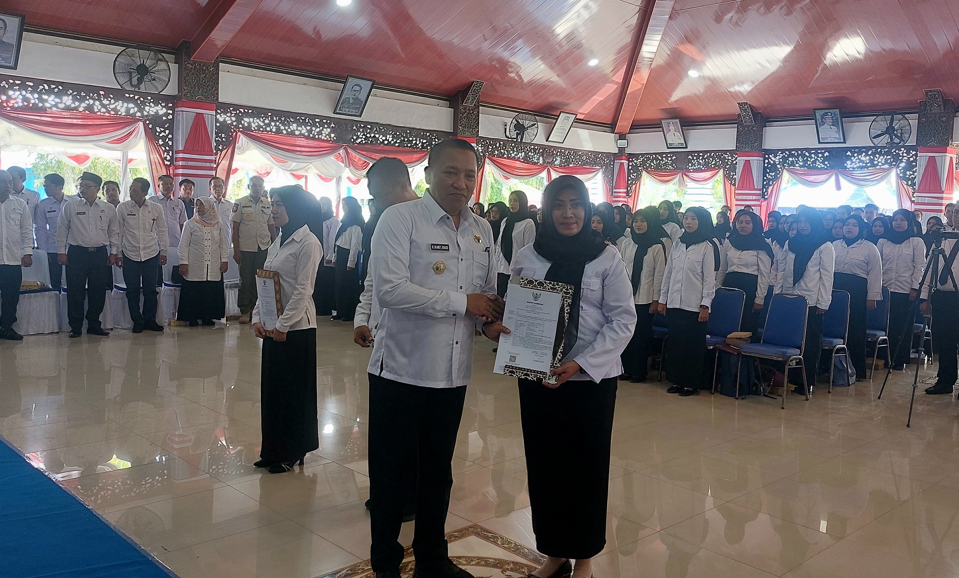 TERIMA SK: Bupati Sampang Slamet Junaidi (kiri) menyerahkan SK pengangkatan pegawai baru di Pendopo Trunojoyo, Kabupaten Sampang, Rabu (30/4). (JUNAIDI PONDIYANTO/JPRM)