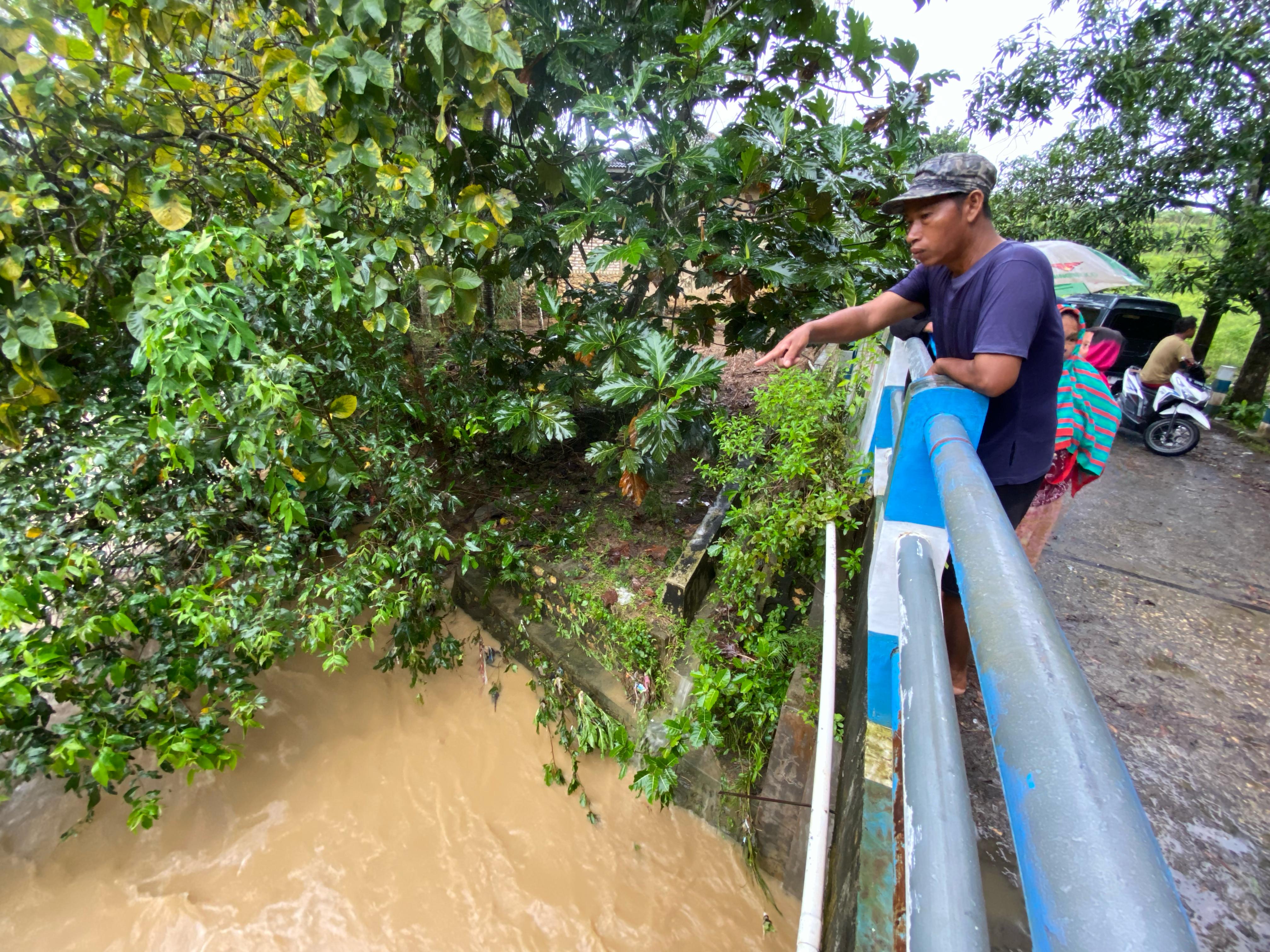 PENELUSURAN: Warga menunjukkan muara sungai bocah yang terhanyut di Desa Palengsanger, Kecamatan Pagantenan, Rabu (13/5). (FAHMI JALIL/JPRM)