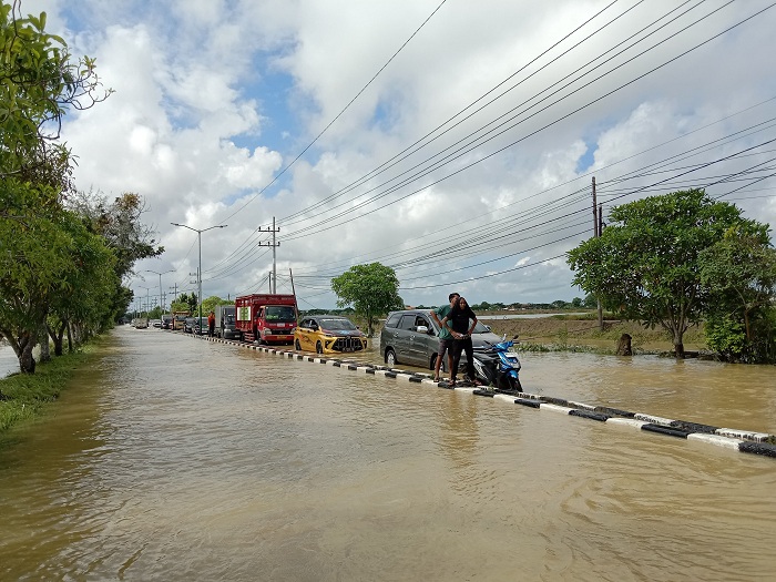 TERDAMPAK: Berbagai jenis kendaraan terjebak banjir di Jalan Raya Sumenep&ndash;Pamekasan, Desa Patean, Kecamatan Batuan, Rabu (14/5). (ERWIN MAULIDIN MM/JPRM)