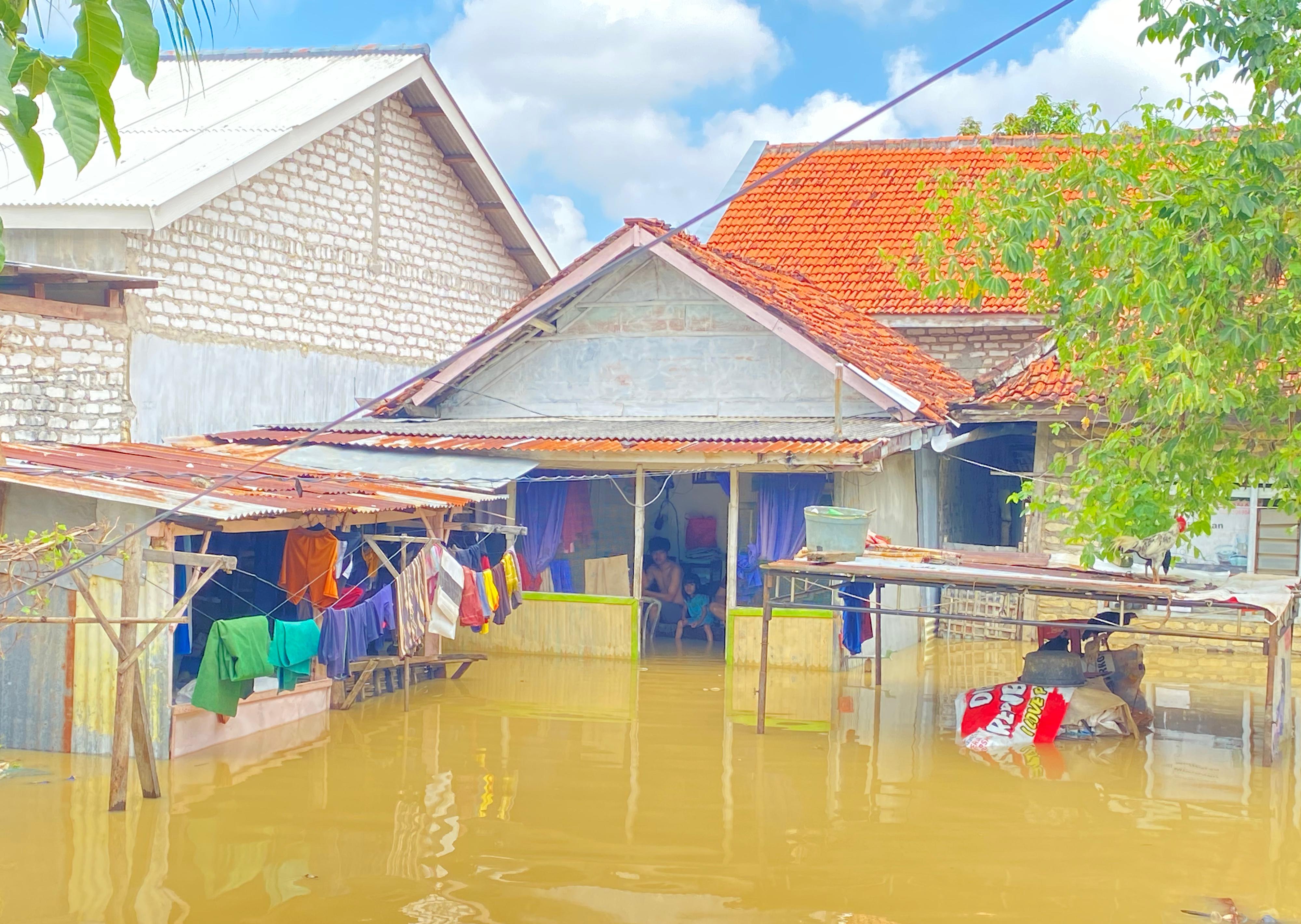 BERTEDUH: Korban banjir berdiam diri di rumahnya di Kelurahan Petemon, Kecamatan Kota Pamekasan, Senin (12/5). (AYU LATIFAH/JPRM)