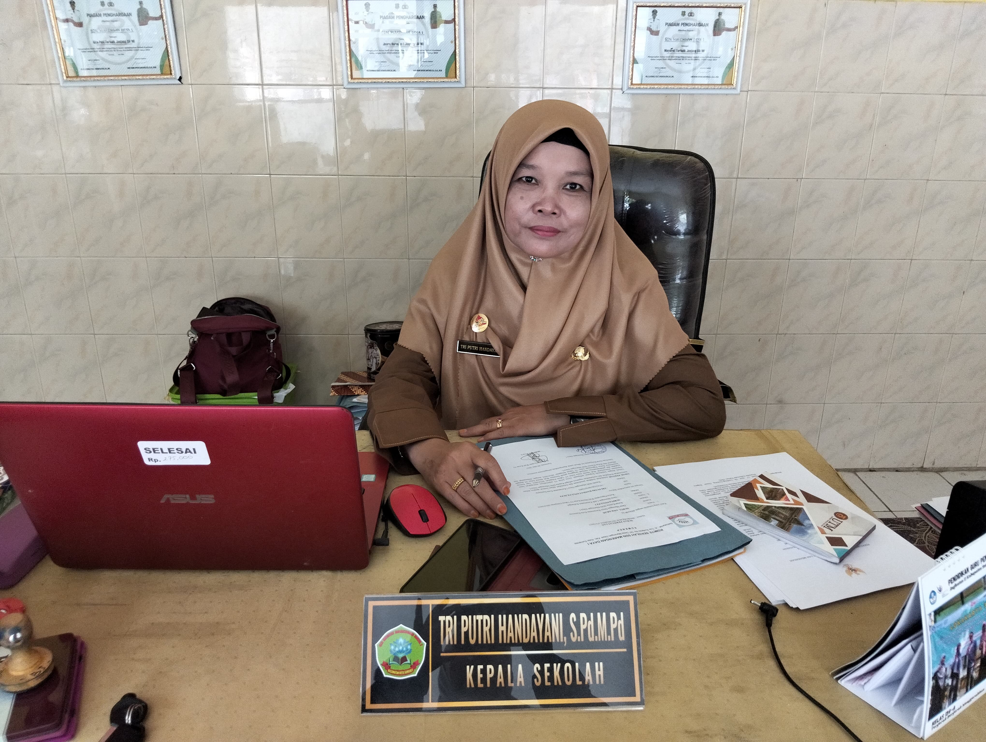 KLARIFIKASI: Kepala SDN Marengan daya I Tri Putri Handayani, S.Pd M.Pd,. memperlihatkan hasil kesepakatan rapat paguyuban wali murid sekaligus surat pernyataan dari Komite dan Ketua Paguyuban