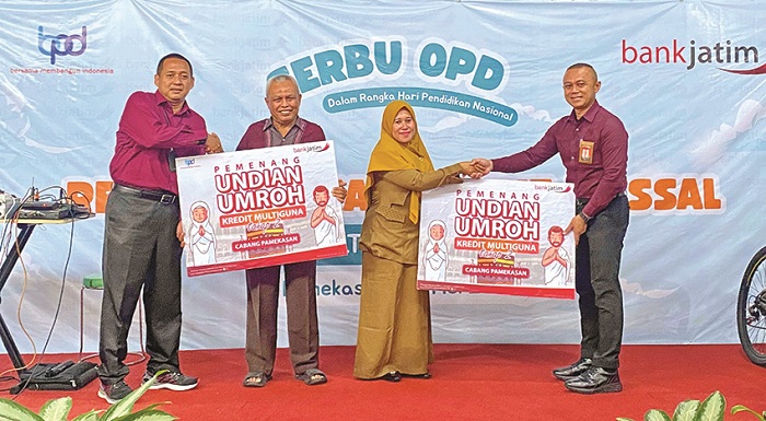 APRESIASI: Pjs Pimcab Bank Jatim Pamekasan Yuda Imawan Sutanto (kanan) dan Pemimpin Bidang Kredit Aditya Rachman (kiri) menyerahkan hadiah umrah Kredit Multiguna tahap II kepada nasabah Senin (26/5).