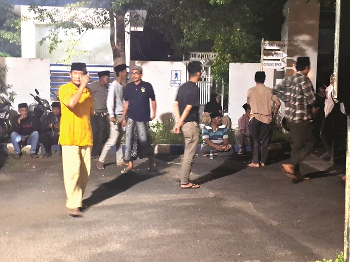 DIKAWAL: Perangkat Desa Batang-Batang Daya, Kecamatan Batang-Batang, mengawal Siti Naisa ketika diperiksa di Mapolres Sumenep, Minggu (25/5) malam. (MOH. LATIF/JPRM)