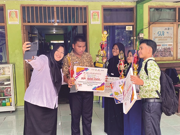 GENERASI EMAS: Kacabdindik Jatim Wilayah Bangkalan Pinky Hidayati selfie dengan murid berkebutuhan khusus yang meraih penghargaan tingkat provinsi di SLB Samudra Lavender kemarin. (JUPRI/JPRM)