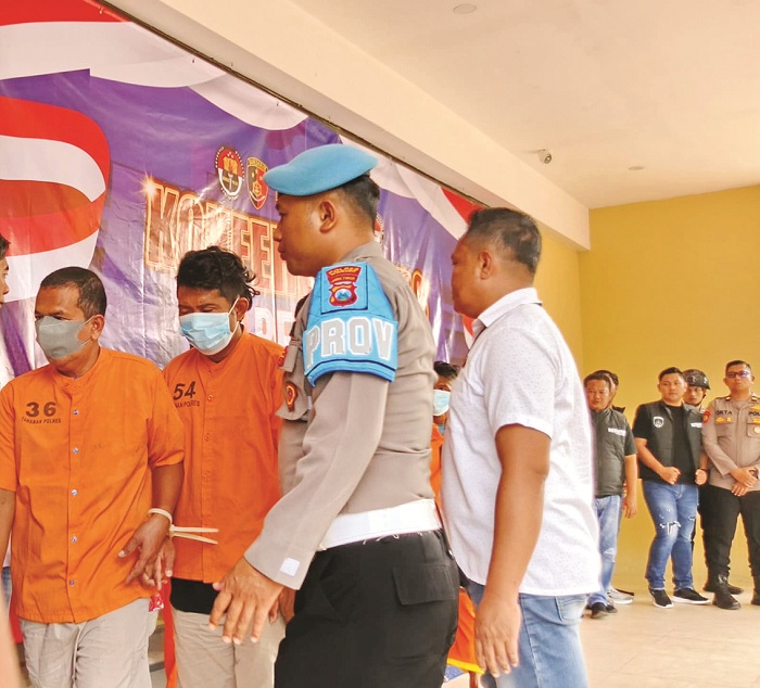 BERBAJU ORANYE: Jufri (nomor baju 36) bersama Syaiful Bahri (nomor baju 54) menuju sel tahanan usai mengikuti konferensi pers di Mapolres Sumenep kemarin. (MOH. LATIF/JPRM)