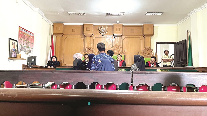 PEMBUKTIAN: Para saksi dan terdakwa mengecek foto perhiasan yang pernah digadaikan dalam sidang kedua di Pengadilan Negeri (PN) Bangkalan Senin (2/6). (ZEINAL ABIDIN/JPRM)