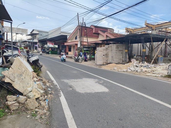 RUSAK BERAT: Pengendara sepeda motor melintas di Jalan Desa Waru Barat, Kecamatan Waru, Pamekasan, Minggu (8/6). (AYU LATIFAH/JPRM)