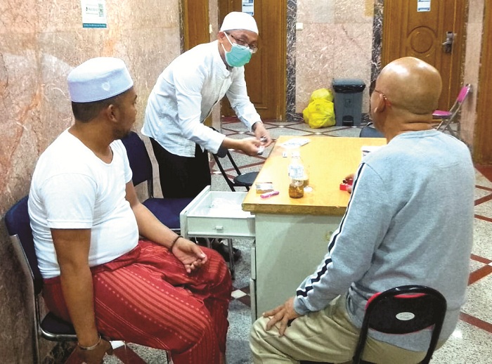 TUMBANG: Petugas kesehatan haji Bangkalan melakukan penanganan medis terhadap jemaah yang jatuh sakit Selasa (10/6). (ZULKIFLI UNTUK JPRM)