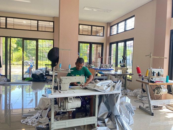 MASIH BERTAHAN: Pelaku industri konfeksi bekerja di gedung sentra IKM di Desa Baengas, Kecamatan Labang, Bangkalan, Kamis (12/6). (ROSATIN NUR/JPRM)