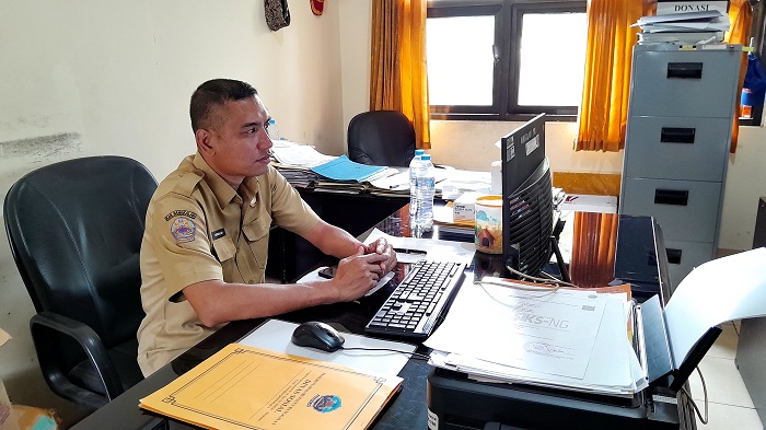TURUN LANGSUNG: Kabid Linjamsos Dinsos Bangkalan Muhammad Aminullah mengecek data sasaran murid Sekolah Rakyat di ruang kerjanya, Selasa (10/6). (M. KHOLIL RAMLI/JPRM)