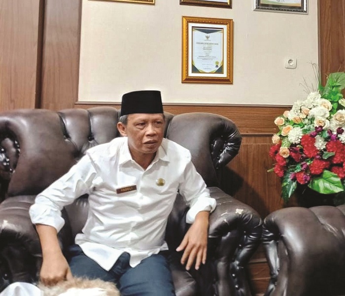 SANTAI: Kepala Dispendik Sampang Mohammad Fadeli berada di kantornya. (UBAIDILLAHIR RAIE/JPRM)