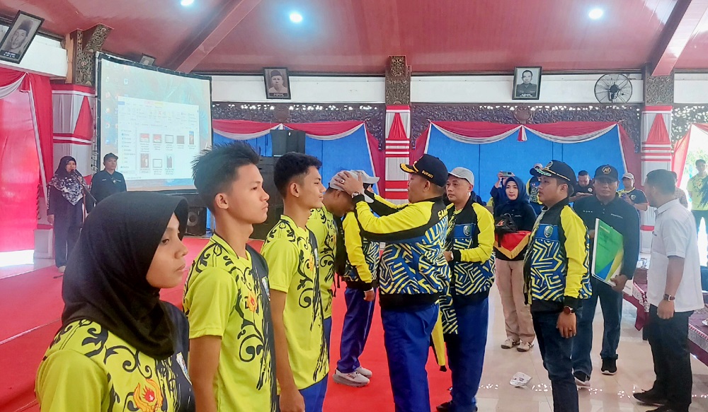 SIMBOLIS: Bupati Sampang Slamet Junaidi memasang topi atlet sebagai tanda pelepasan di Pendopo Trunojoyo Sampang kemarin.