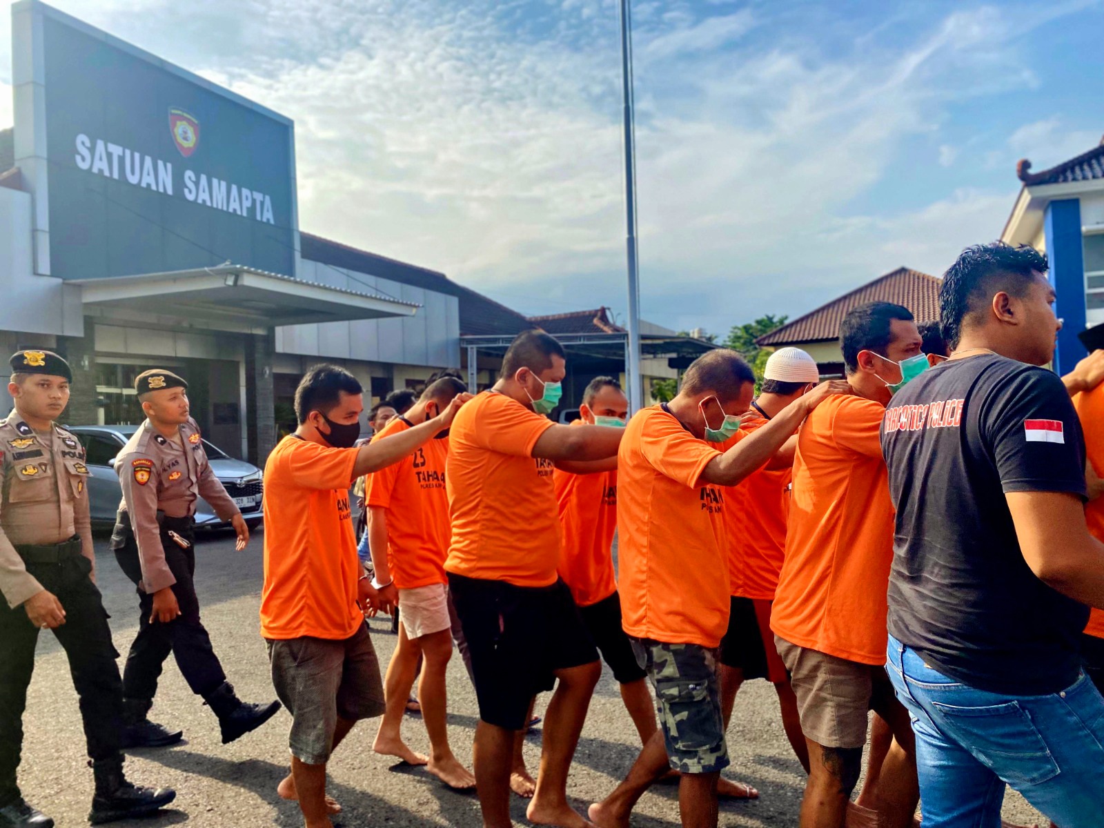BAJU ORANYE: Tersangka kasus dugaan penyalahgunaan narkoba digiring menuju ruang konferensi pers di Mapolres Pamekasan Kamis (19/6). (MOH. IQBAL AFGANI/JPRM)