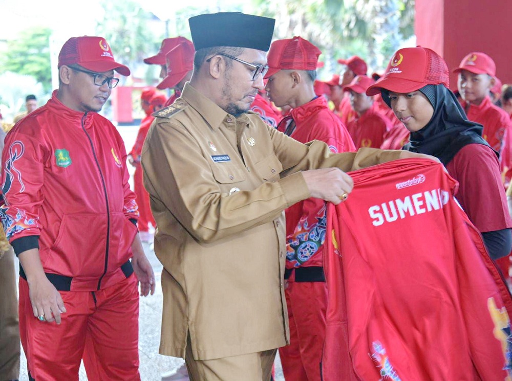 BERI SEMANGAT: Bupati Sumenep Achmad Fauzi Wongsojudo memasangkan jaket kepada para atlet porprov di halaman kantor pemkab, Senin (16/6).